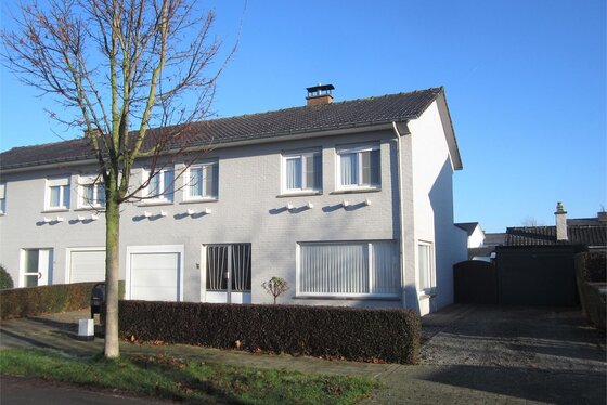 Charmante halfopen bebouwing op 586m² met twee garages en aangelegde zonnige tuin.
